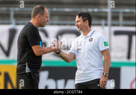 Ulm, Deutschland. September 2020. Fußball: DFB Cup, SSV Ulm 1846 Fußball - Erzgebirge Aue, 1. Runde. Aues Trainer Dirk Schuster (r) schüttelt sich die Hände mit Ulmer Trainer Holger Bachthaler. Quelle: Stefan Puchner/dpa - WICHTIGER HINWEIS: Gemäß den Bestimmungen der DFL Deutsche Fußball Liga und des DFB Deutscher Fußball-Bund ist es untersagt, im Stadion und/oder aus dem Spiel aufgenommene Aufnahmen in Form von Sequenzbildern und/oder videoähnlichen Fotoserien zu nutzen oder auszunutzen./dpa/Alamy Live News Stockfoto