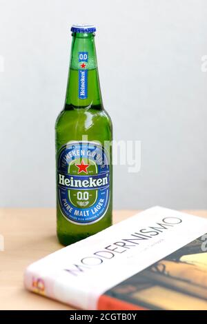 Grüne Glasflasche Heineken Bier und Buch Stockfoto