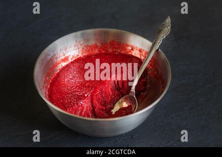 Hausgemachtes Erdbeereis in der Stahlschüssel auf dunklem Hintergrund. Bio-Eis mit Zucker. Stockfoto