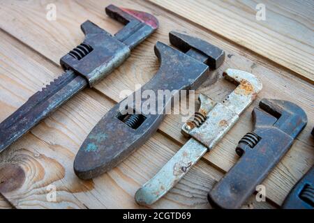 Alte verstellbare Schraubenschlüssel auf Holztisch, Vintage-Werkzeuge. Labor Day. Stockfoto