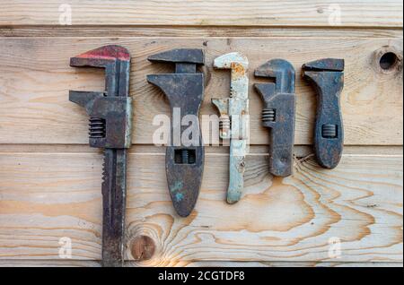 Alte verstellbare Schraubenschlüssel auf Holztisch, Vintage-Werkzeuge. Labor Day. Stockfoto