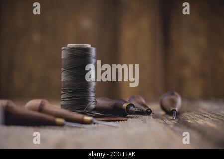 Leder Handwerk Werkzeuge auf alten Holztisch. Lederwerkstatt. Stockfoto