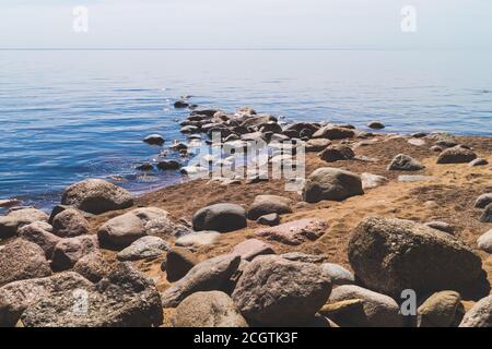 Weg zum Meer mit Steinen am Sandstrand. Sommerlandschaft. Horizont-Linie Stockfoto