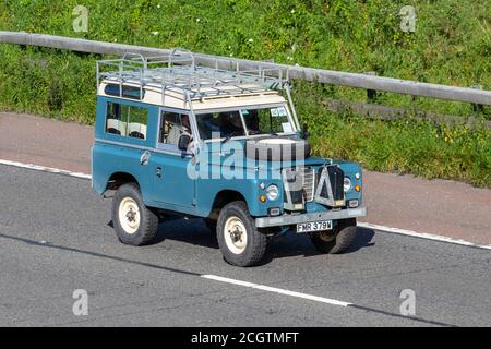 1980 80s blau weiß Land Rover 88' - 4 CYL; Fahrzeuge mit bewegtem Verkehr, Fahrzeuge, die Fahrzeuge auf britischen Straßen fahren, 80s Motoren, die auf dem Autobahnnetz der Autobahn M6 fahren. Stockfoto