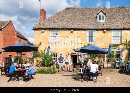 Cotswolds Pub The Crown & Trumpet mit Leuten, die an einem sonnigen Tag draußen trinken. Touristen in einem Pub Biergarten, Broadway, England, Großbritannien. Stockfoto