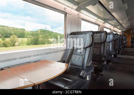 Intercity-Express-Zuginnenraum mit leeren Sitzen, in der Business-Klasse, in Bewegung. Innen von deutschen Hochgeschwindigkeitszug, in erster Klasse mit gemütlichen Stühlen. Stockfoto