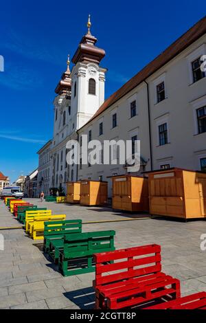 loyola saint ignatius Kirche mit bunten Picknickbänken in Gyor szechenyi . Stockfoto