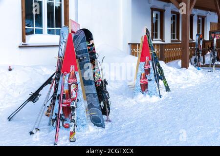 Skier stehen auf speziellen Ständen in der Nähe des Resortgebäudes. Stockfoto