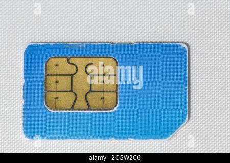 Gebrauchte zerkratzte blaue Handy-sim-Karte Makro auf weiß Stockfoto