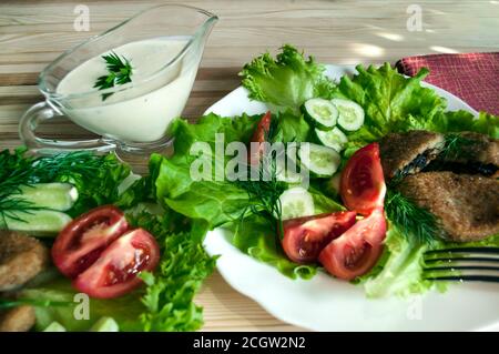 Portion Kartoffelschnitzel auf einem Teller mit Gemüse und Gemüse. Selektiver Fokus. Stockfoto