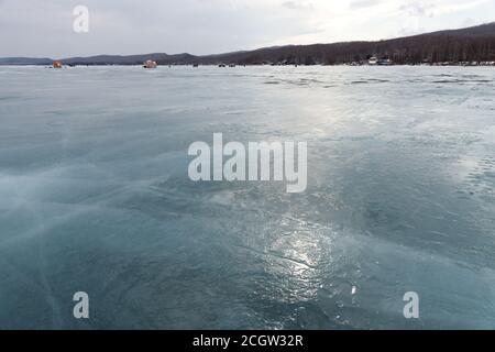 Eis auf einem auftauenden Great Lake mit Fischern in der Ferne. Region Krasnojarsk. Russland. Stockfoto