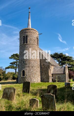 Die rund getürmte Feuersteinkirche St. Mary in Titchwell an der Nordnorfolkküste. Stockfoto