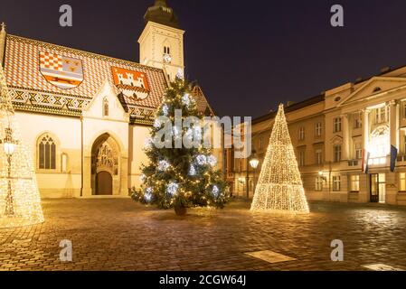 Beleuchtete Weihnachtsbäume vor der Markuskirche am Markusplatz in der Oberstadt Zagreb während der Adventszeit, Kroatien. Stockfoto