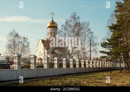 Orthodoxe Kirche St. Andreas der erste genannt (2011) mit einem Zaun im Vordergrund an einem sonnigen Herbsttag in der Stadt Lesosibirsk. Stockfoto