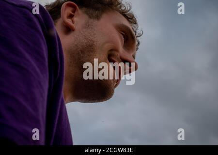 Sehr niedriges Porträt eines jungen Mannes draußen Stockfoto