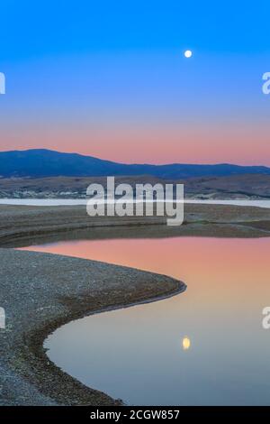 Vollmond über dem Canyon Ferry Lake bei Sonnenaufgang in der Nähe von townsend, montana Stockfoto