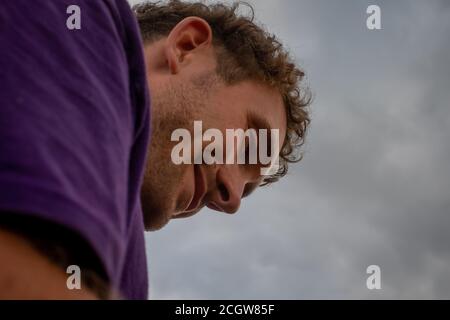 Sehr niedriges Porträt eines jungen Mannes draußen Stockfoto