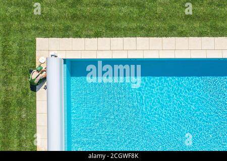 Outdoor Wohn Schwimmbad Wartung Skimmer Filter Reinigung durchgeführt von Professional Kaukasischen Pool Technician. Industriedesign. Stockfoto