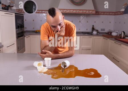 Junger Mann, der mit Schuld auf ein Chaos auf der Zähler Stockfoto