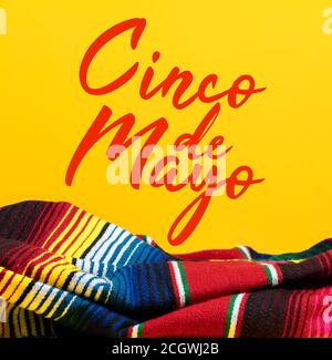 Mexikanische Serape Decke auf gelbem Hintergrund mit Cinco de Mayo. Stockfoto