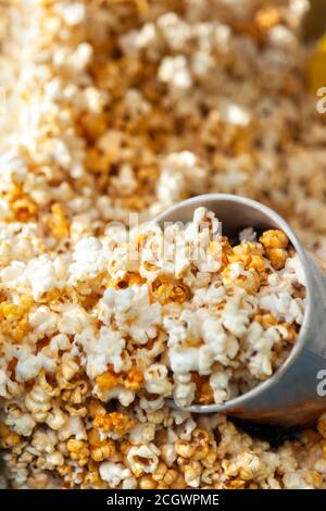 Popcorn in Karton. Ein Haufen Popkorn im Behälter hinter dem Glas Stockfoto