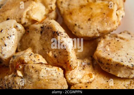 Stücke gebratenes Hähnchenfilet mit schwarzem Pfeffer bestreut Stockfoto