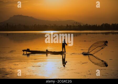 Srinagar, indisch kontrolliertes Kaschmir. September 2020. Ein Fischer wirft Netz, um Fische am Dal See während eines Sonnenuntergangs in Srinagar, der Sommerhauptstadt von indisch-kontrolliertem Kaschmir, Sept. 12, 2020 zu fangen. Quelle: Javed Dar/Xinhua/Alamy Live News Stockfoto