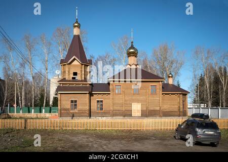 Eine kleine Holzkirche am Eingang der Stadt Yeniseisk mit einem Auto davor. Region Krasnojarsk. Russland. Stockfoto