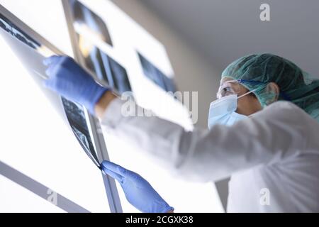 Ärztin betrachtet die Röntgenaufnahme des Patienten im Operationssaal Stockfoto