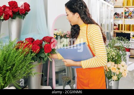 Blumenhändler prüft Blumen Stockfoto