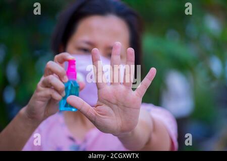 Asain Frauen spry Alkohol, um ihre Hand zu reinigen, Konzept für Coronavirus, Covit-19 Prävention und Desinfektion. Stockfoto