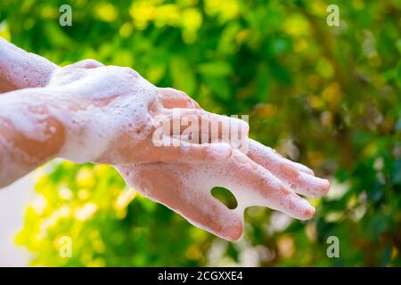Frauen waschen Hände mit Seife und Wasser auf grün verwischen Hintergrund. Stockfoto