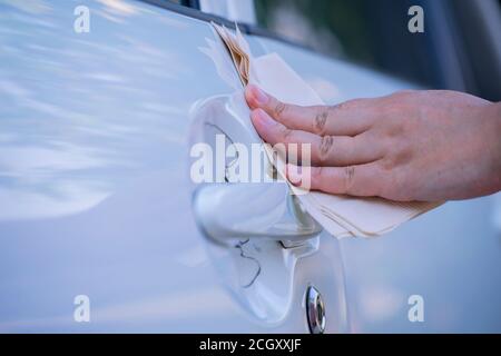 Asiatische Frauen Spry Seife und saubere Autotür Griff mit Serviette. Stockfoto