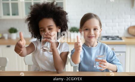 Portrait von glücklichen multirassischen Kindern, die Wasser trinken. Stockfoto