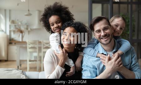 Glückliches multirassisches Paar genießen süße Familie Moment mit Kindern. Stockfoto