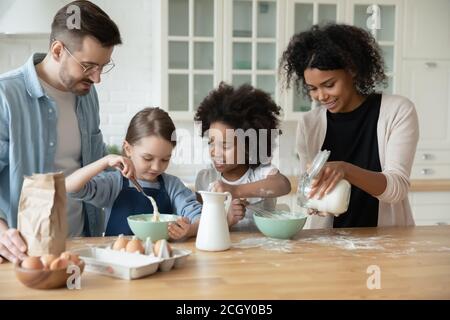 Glückliche multiethnische Familie Vorbereitung Teig für Gebäck. Stockfoto