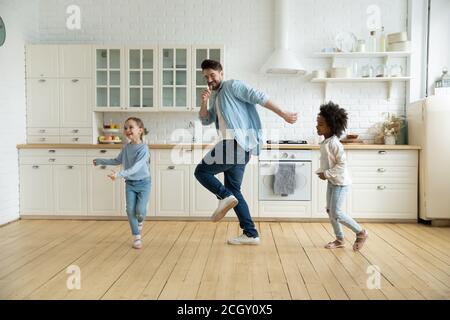 Überglücklich internationale Familie tanzen, genießen Wochenende Zeit. Stockfoto