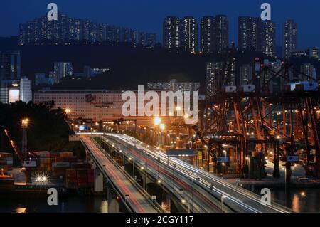 Kwai Tsing Container Terminals und Autobahnbrücke bei Nacht, Hafen von Hong Kong, mit modernen Terminals godown und Wohngebäuden Stockfoto