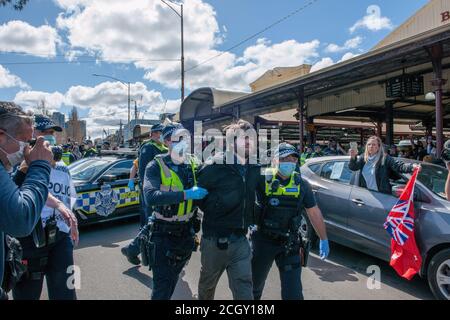 Melbourne, Australien. September 2020. Viktorianische Polizisten führen einen verhafteten Demonstranten auf den Queen Victoria Markets während eines Popup-Anti-Maske- und Anti-Lockdown-Protests auf dem Markt in Melbourne Australia fort. Kredit: Michael Currie/Alamy Live Nachrichten Stockfoto