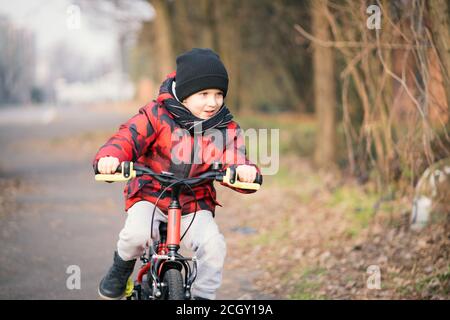 Fröhlicher kleiner Junge beim Fahrradfahren im Park. Stockfoto