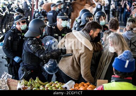 Melbourne, Australien. September 2020. Polizeibeamte der Victoria-Polizei drängen sich mit Schilden und Schlagstöcken auf Demonstranten in die Obst- und Gemüseschuppen auf den Queen Victoria Markets, um einen Anti-Maske- und Anti-Lockdown-Popup-Protest in Melbourne Australien aufzubrechen. Kredit: Michael Currie/Alamy Live Nachrichten Stockfoto