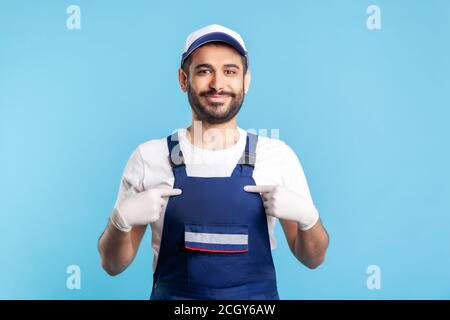 Das bin ich! Glücklich zufrieden Handwerker in Overalls und Hygiene-Handschuhe zeigt sich, stolz auf Leistung. Beruf der Dienstleistungsbranche, Kurier de Stockfoto