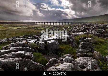 Ribblehead Viadukt auf der Settle-Carlisle-Bahn im Yorkshire Dales National Park, von den nahe gelegenen Kalksteinfelsen während eines Regensturms gesehen Stockfoto