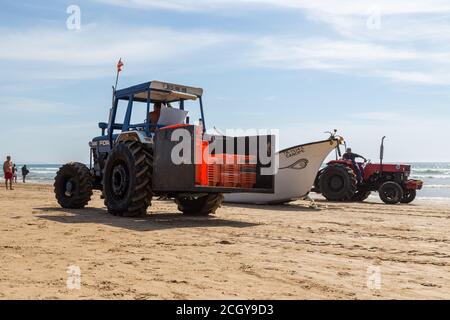 Costa da Caparica, Portugal - 10. September 2020: Eine Kunst der Fischer Schleppnetzfischfang vom touristischen Strand mit einem Traktor. Urlauber beobachten und hellen Stockfoto