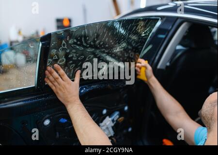 Arbeiter installiert benetzte Auto Färbung, Tuning-Service Stockfoto