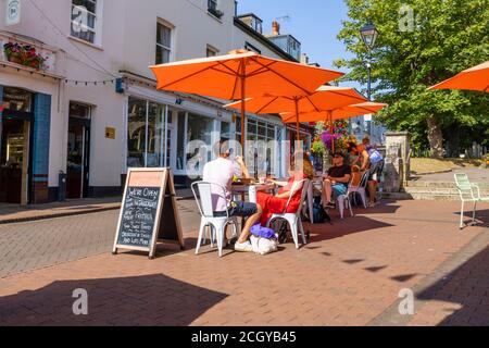 Essen im Freien an einem sonnigen Tag im Stadtzentrum von Sidmouth, einer Küstenstadt in Devon, auf dem Weltkulturerbe der Jurassic Coast Stockfoto