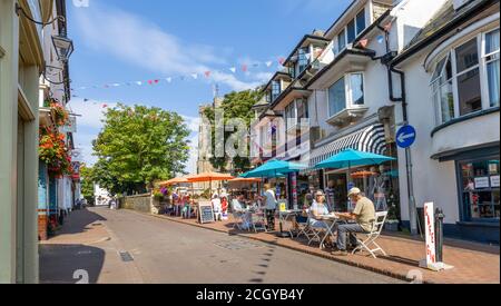 Essen im Freien an einem sonnigen Tag im Stadtzentrum von Sidmouth, einer Küstenstadt in Devon, auf dem Weltkulturerbe der Jurassic Coast Stockfoto