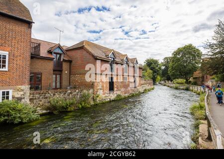 Der Fluss Itchen fließt durch historische Gebäude am Flussufer an den Wehren in Winchester, Hampshire, Südengland Stockfoto