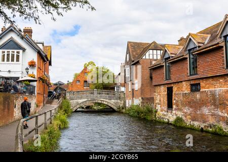 Der Fluss Itchen fließt durch die Wehre in Winchester, Hampshire, Südengland Blick in Richtung City Mill und der historischen Steinbrücke Stockfoto