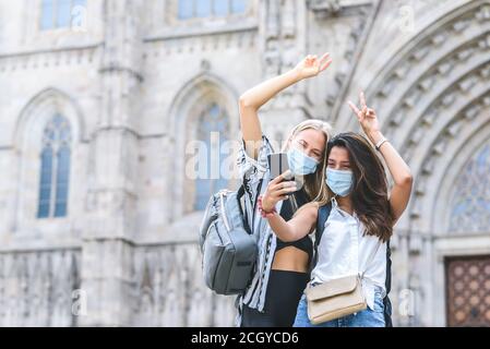 kaukasische und indische Freundinnen mit Smartphone zu nehmen Ein Selbstporträt mit der Kathedrale von Barcelona im Hintergrund Stockfoto